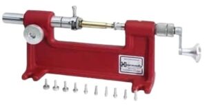 High-precision reloading press with red metal frame and various small tools for firearm ammunition assembly and reloads.