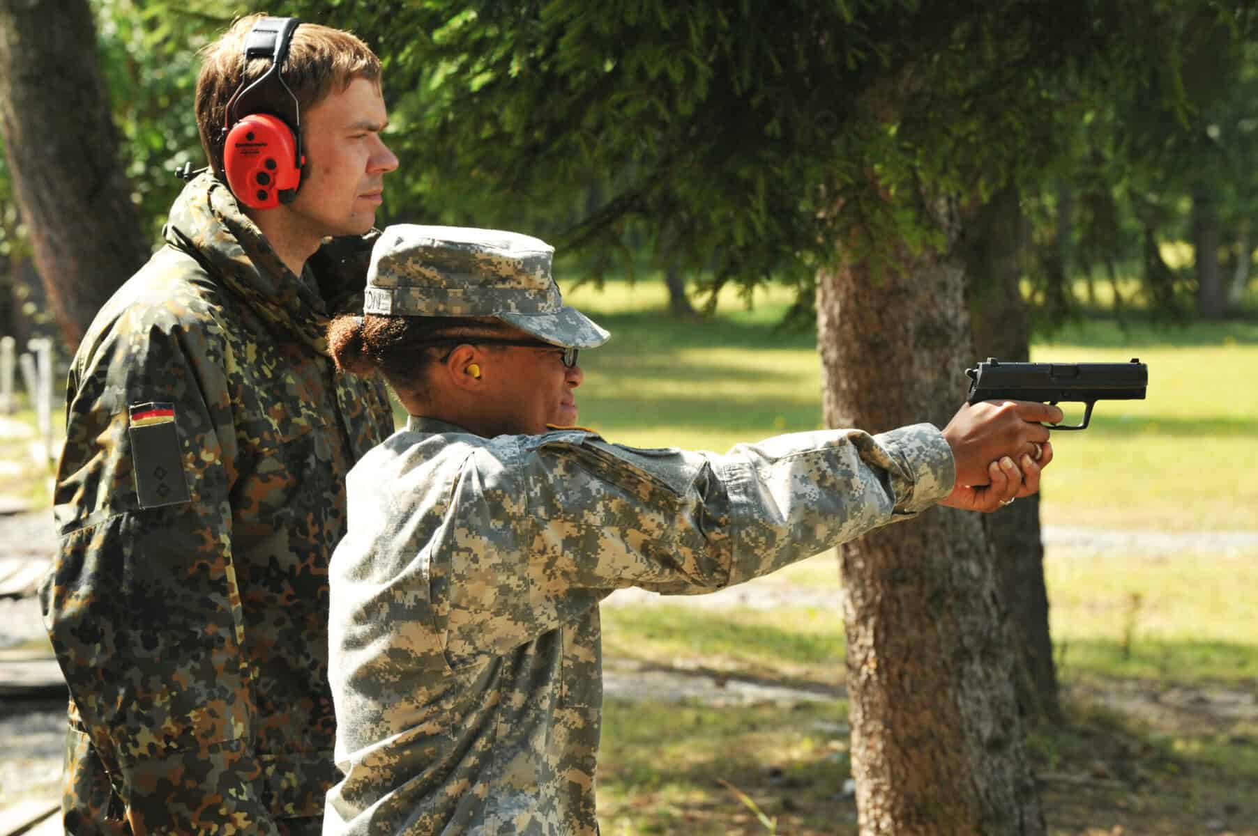 Shooter wearing hearing protection earmuffs at a firing range