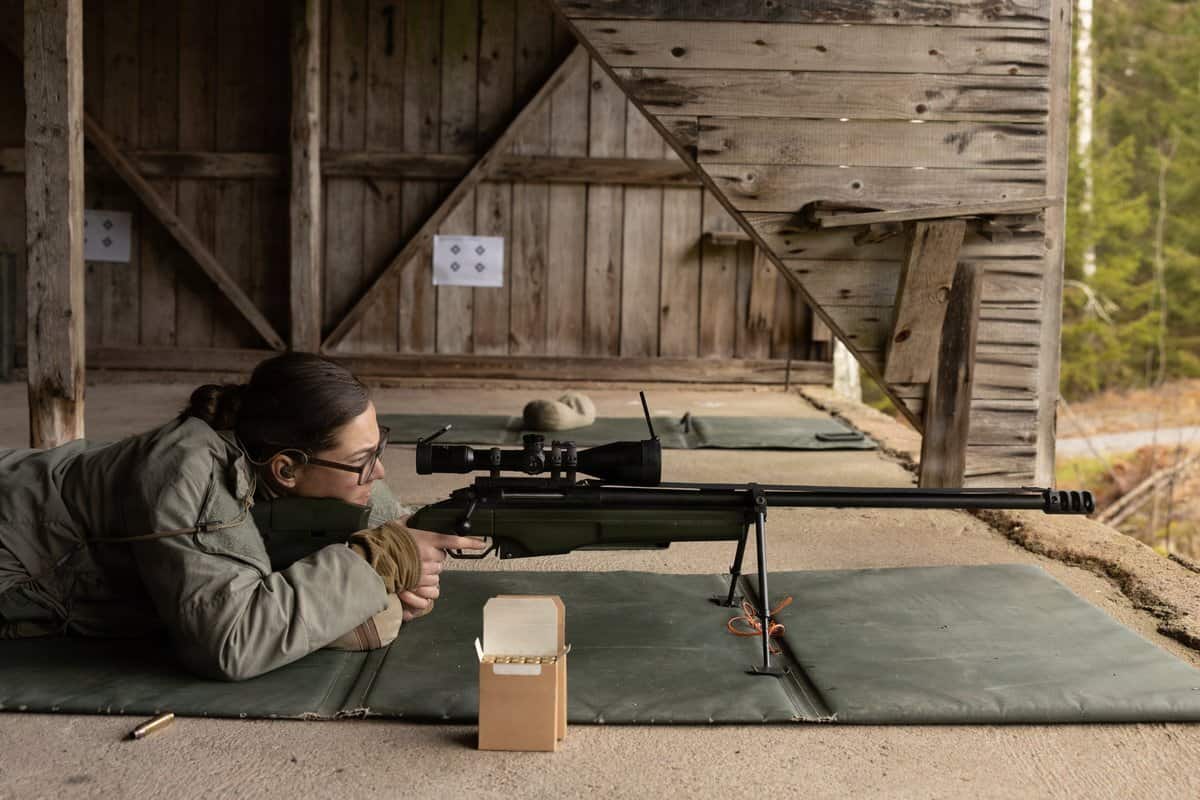 long range shooting beginners - Shooter in prone position with scoped precision rifle on bipod at long-range rifle range