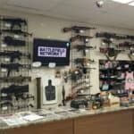Interior of a gun shop showing firearms on wall display and counter
